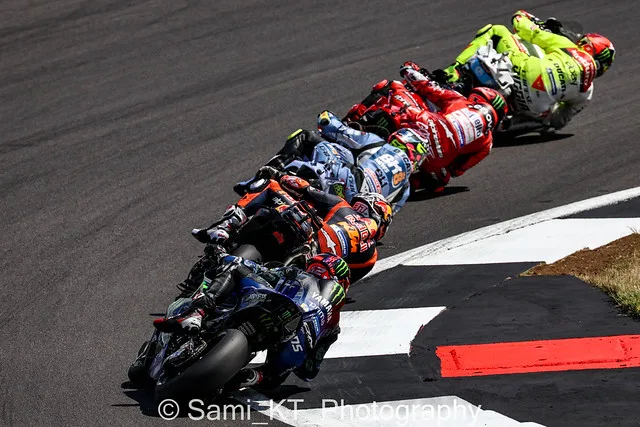 A pack of racing motorbikes leaning into a corner